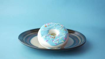 Donut cookie treat picked up from plate on blue background video