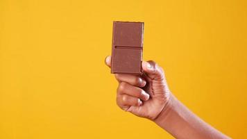 Chocolate held in front of yellow background video