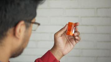 Au-dessus de l'épaule d'un homme regardant une bouteille de pharmacie orange video