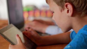 twee broers gebruik makend van laptop en ipod Aan tafel Bij huis video