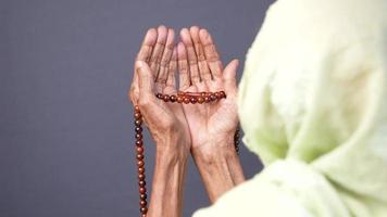 Muslim woman with beads and head scarf praying video