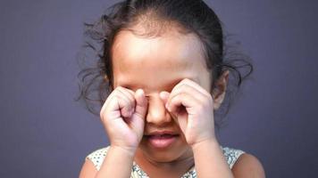 Little girl rubs her eyes with hands video