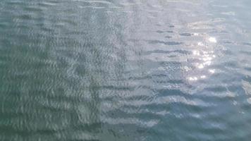 Detailed close up view on water surfaces with ripples and waves and the sunlight reflecting at the surface video