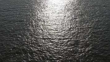 Water surface with small waves reflecting light and clouds. video