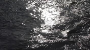 surface de l'eau avec de petites vagues reflétant la lumière et les nuages. video