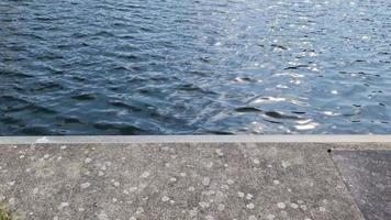 detaillierte nahaufnahme auf wasseroberflächen mit wellen und wellen und das sonnenlicht, das an der oberfläche reflektiert wird video