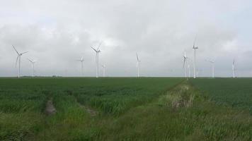Panoramic view on alternative energy wind mills in a windpark with a cloudy sky. video