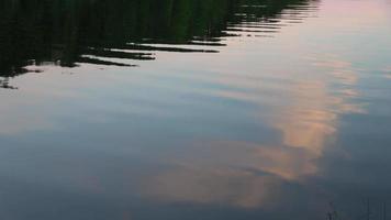 water oppervlakte met klein golven reflecterend licht en wolken. video