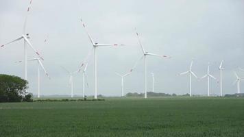 panoramico Visualizza su alternativa energia vento mulini nel un' windpark con un' nuvoloso cielo. video