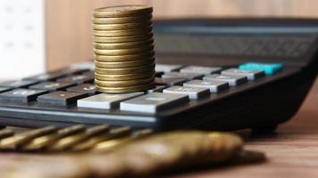 A pile of coins on a calculator close up video