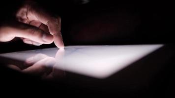 Close up of person using a touch screen tablet in the dark video