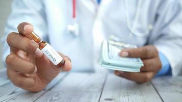 Doctor holds a vaccine bottle and folded money bills video