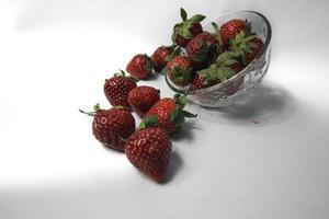 Fresh strawberries in a transparent glass bowl photo