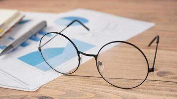 lunettes à monture ronde sur table, infographie imprimée sur papier video