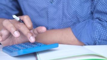 Man uses calculator, close up video