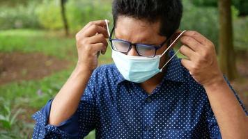 A man puts on a disposable mask video