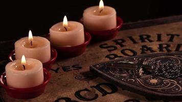 Christian religion symbol Cross and Ouija Witch Board in Candle Light video