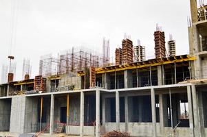 The process of construction and repair of a new modern cement concrete stone pannel monolithic frame-block building of a house with iron reinforcement at an industrial construction site photo