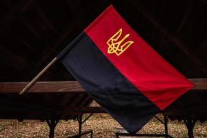 Ukrainian Nationalists OUN UPA flag. Black and red Ukraine flag with coat of arms trident. photo