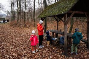 Kids having rest in autumn forest with roof shelter and picnic table. photo