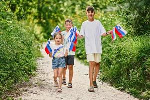 Three kids hold slovenian flags in Triglav National Park, Slovenia. photo