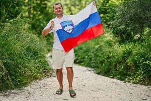 Man hold slovenian flag in Triglav National Park, Slovenia. photo