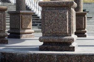 Large brown marble columns close-up on the background of the stairs in vintage style. Urban architecture. Tourism concept photo