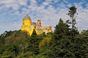 Park and National Palace of Pena in Sintra, Portugal during a sunny day with clouds. Unesco World Heritage. Historic visits. Holidays and vacation tourism. Colorful palace. Most visited places. photo