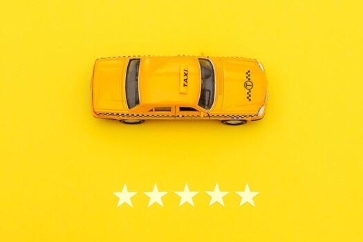 taxi de coche de juguete amarillo y calificación de 5 estrellas aislado sobre fondo amarillo. aplicación de teléfono inteligente del servicio de taxi para buscar en línea llamadas y reservar el concepto de taxi. símbolo de taxi. copie el espacio foto