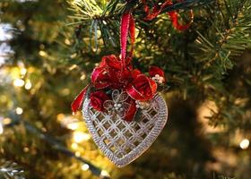 White filigree heart Christmas ornament with red bow photo
