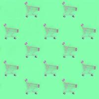 Shopping addiction, shopping lover or shopaholic concept. Many small empty shopping carts perform a pattern on a pastel colored paper background. Flat lay composition, top view photo