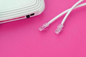 Internet router and Internet cable plugs lie on a bright pink background. Items required for Internet photo