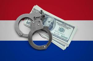 Paraguay flag  with handcuffs and a bundle of dollars. Currency corruption in the country. Financial crimes photo