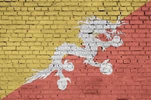 Bhutan flag is painted onto an old brick wall photo