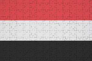 Yemen flag  is depicted on a folded puzzle photo