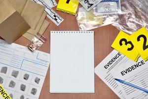 Paperwork during crime scene investigation process in csi laboratory. Evidence labels with fingerprint applicant and many confiscated personal items on wooden table photo