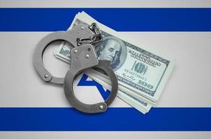 Israel flag  with handcuffs and a bundle of dollars. Currency corruption in the country. Financial crimes photo