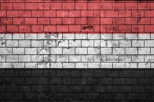 la bandera de yemen está pintada en una vieja pared de ladrillos foto