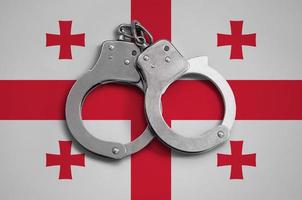 Georgia flag  and police handcuffs. The concept of observance of the law in the country and protection from crime photo