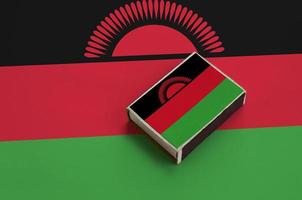 Malawi flag  is pictured on a matchbox that lies on a large flag photo