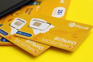 TERNOPIL, UKRAINE - JULY 5, 2022 Lifecell new sim card with free contract on yellow background. Lifecell is ukrainian mobile telephone network operator and provider of wireless connection photo