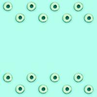 Many small plastic donuts lies on a pastel colorful background. Flat lay minimal pattern. Top view photo