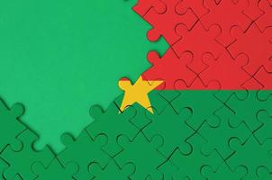 Burkina Faso flag  is depicted on a completed jigsaw puzzle with free green copy space on the left side photo