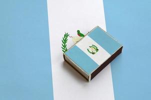 Guatemala flag  is pictured on a matchbox that lies on a large flag photo