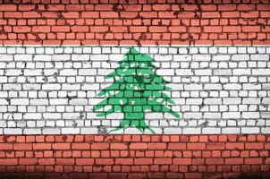 la bandera de líbano está pintada en una vieja pared de ladrillos foto