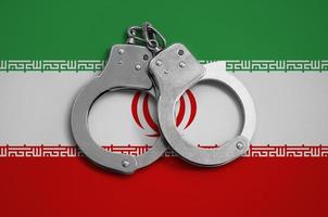 Iran flag  and police handcuffs. The concept of observance of the law in the country and protection from crime photo