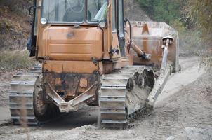 agregado de cantera con maquinaria pesada. Excavadora de oruga con retroexcavadora que conduce a la cantera del sitio de construcción foto