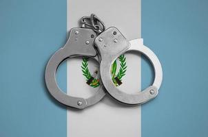 Guatemala flag  and police handcuffs. The concept of observance of the law in the country and protection from crime photo