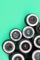 Several photographic lenses lie on a bright turquoise background. Copy space photo