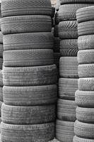 Old used tires stacked with high piles in secondary car parts shop garage photo